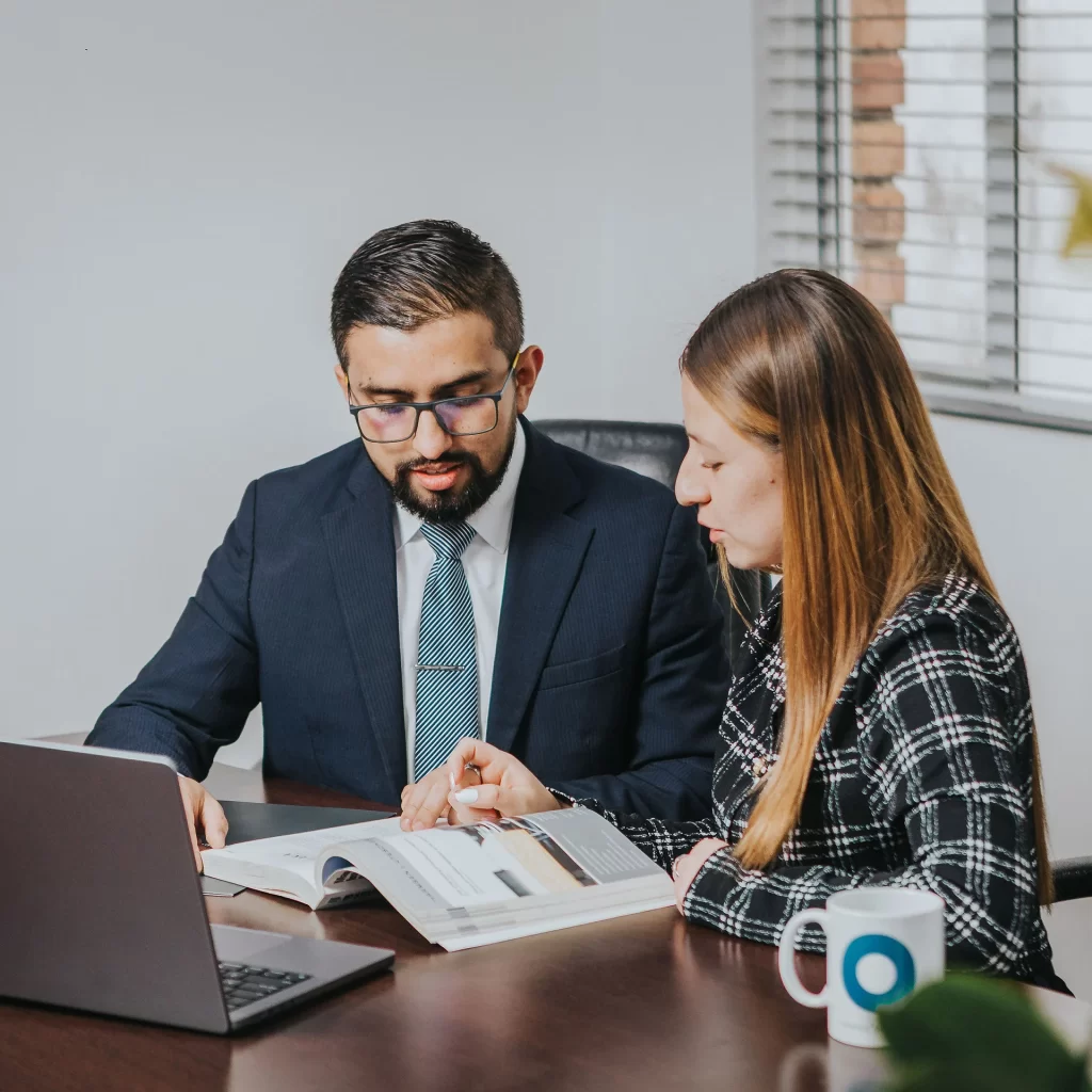 Nuestra firma legal especializada en Colombia abogados expertos leyendo documentos de una firma legal especializada en Colombia llamada Muñoz Abogados